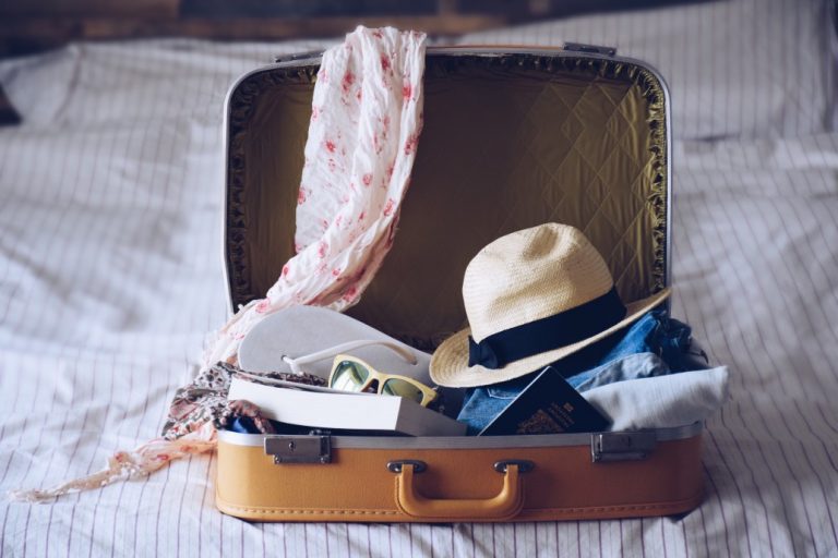 packing-yellow-vintage-suitcase-with-summer-vacation-travel-items-getting-ready-for-vacation-on-the_t20_GGk0E6-768x512