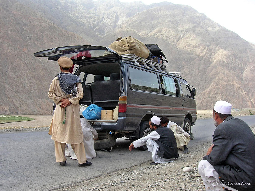 Stopping-to-repair-a-tire-on-local-bus-ride-in-Afghanistan